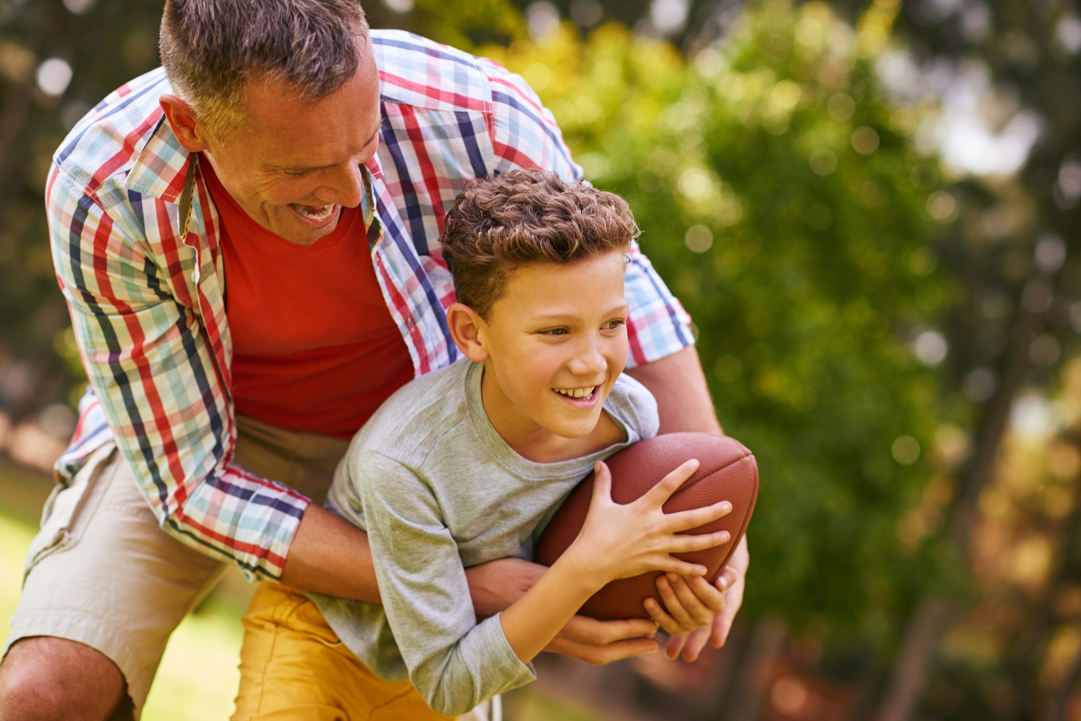 Father and son engaging outdoors with a footbal