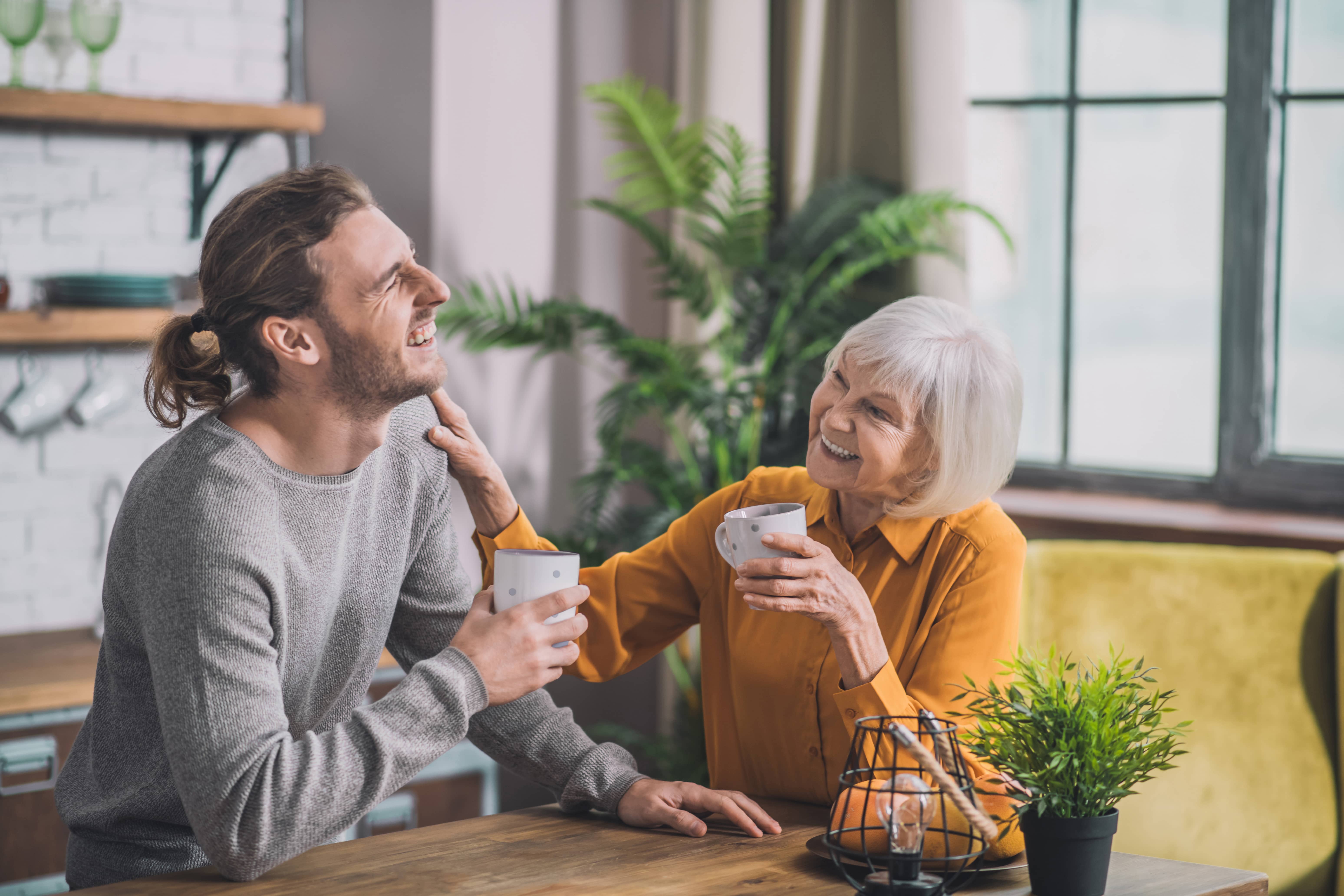 Grey-haired mom having coffee with son_AdobeStock_313588974 Compressed