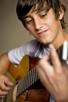 Teen boy playing guitar
