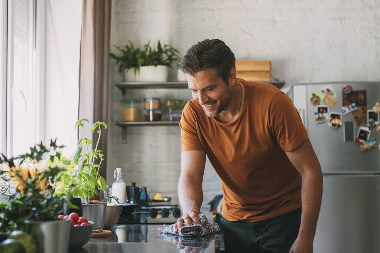 Handsome-Young-Man-Cleaning-a-Kitchen-Counter-with-a-Mop-1297236827_Compressed