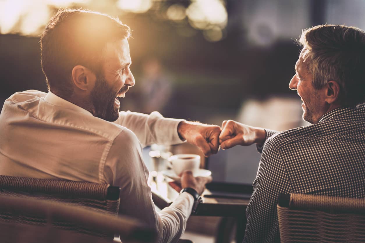 Happy businessmen doing a fist-bump and celebrating an achievement.