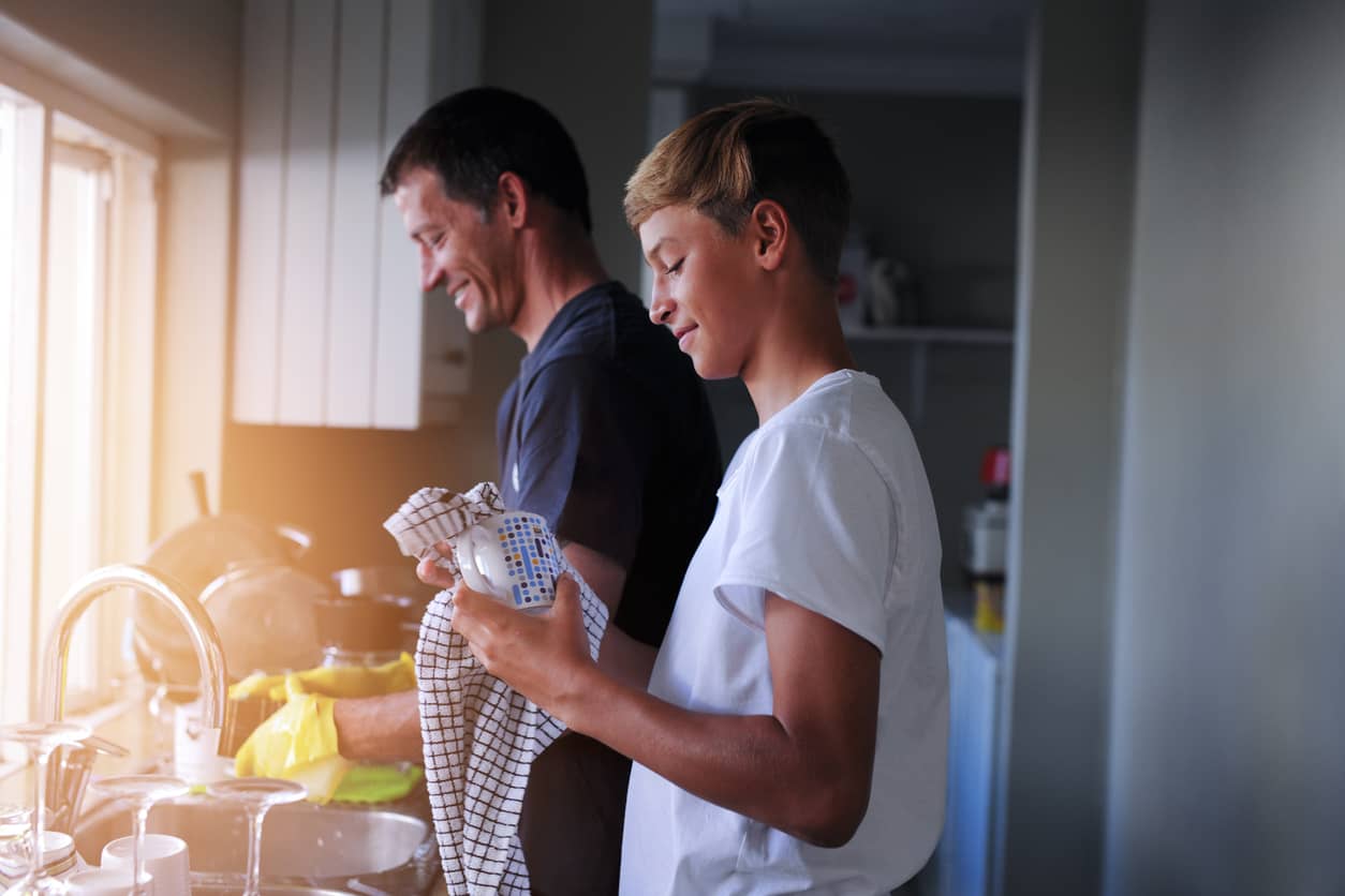 Father with teenage sone doing dishes