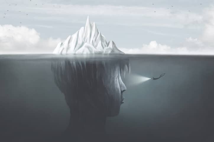 An abstract illustration of an iceberg with a scuba diver shining a light on a face under the surface.