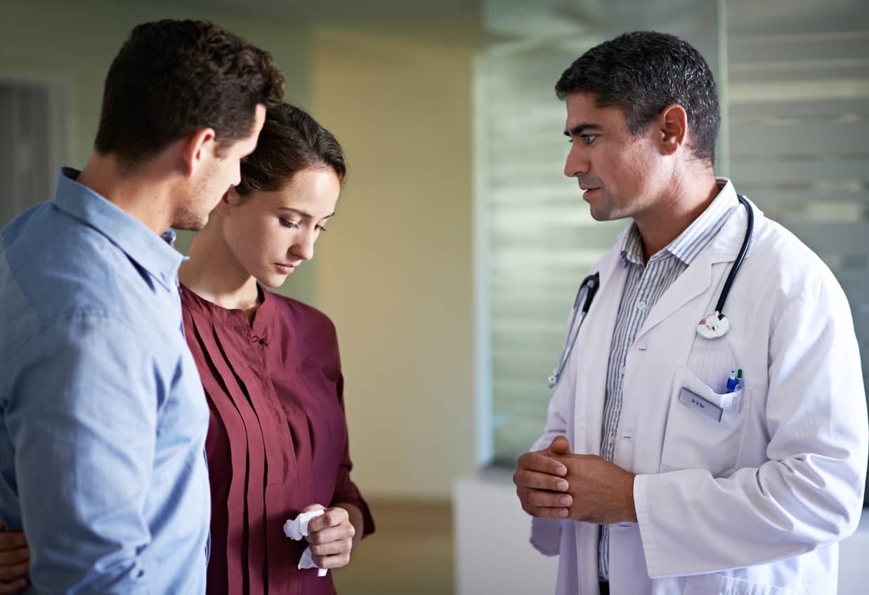 Doctor expressing cognitive empathy to a sad couple