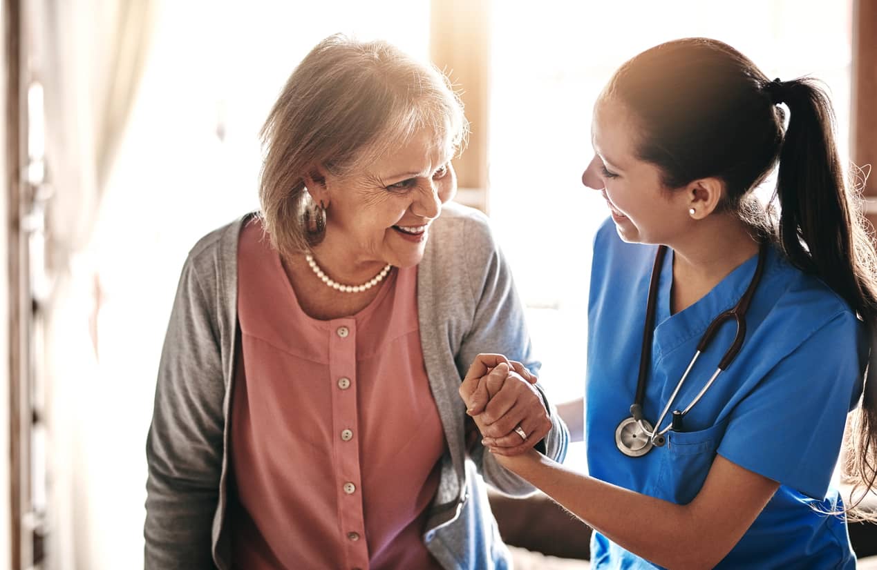 A nurse helps an elderly lady with empathy.