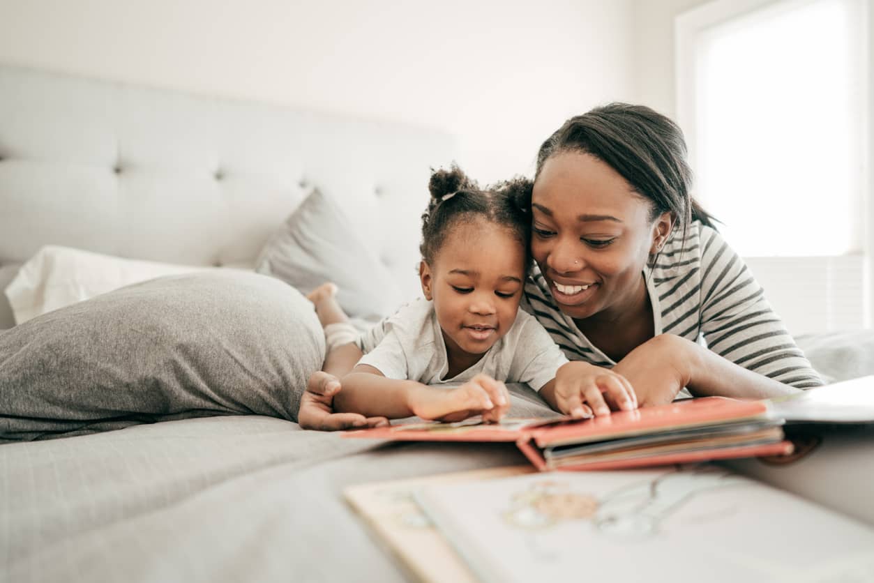 A mother encouraging a growth mindset by reading a book with her preschooler.