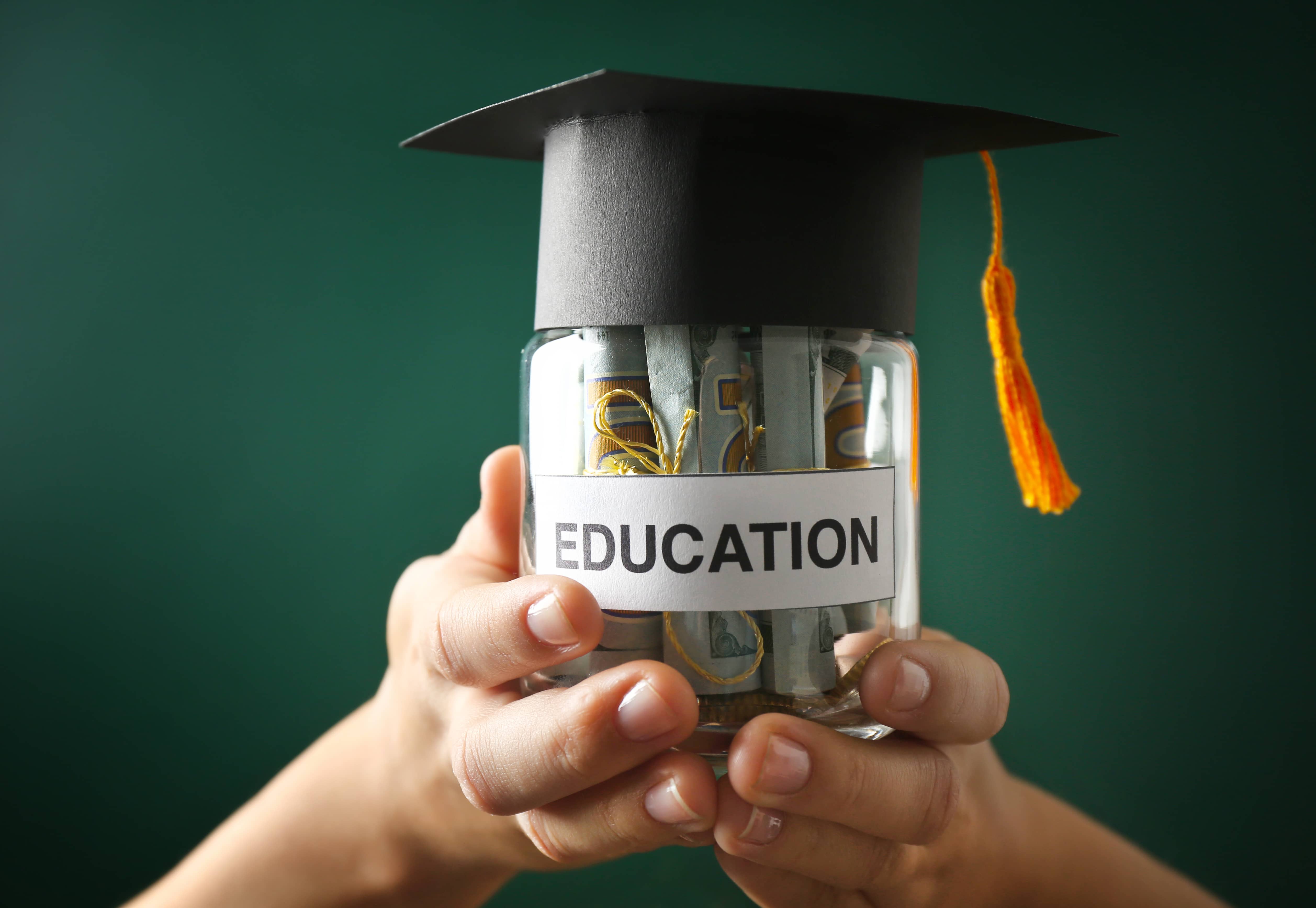 Jar of money with graduation cap; saving for college