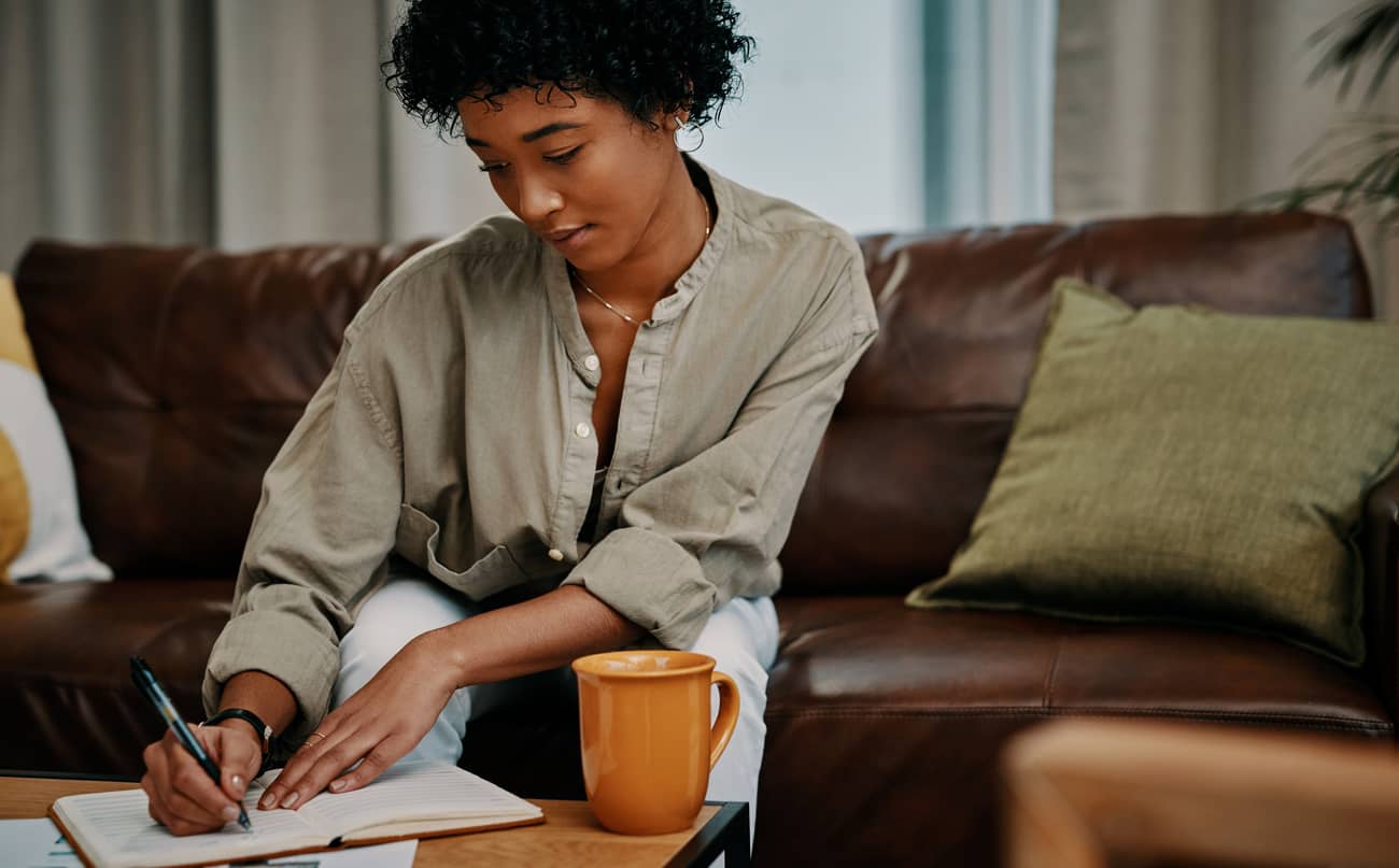 A woman journaling and doing an emotional intelligence exercise in her journal.