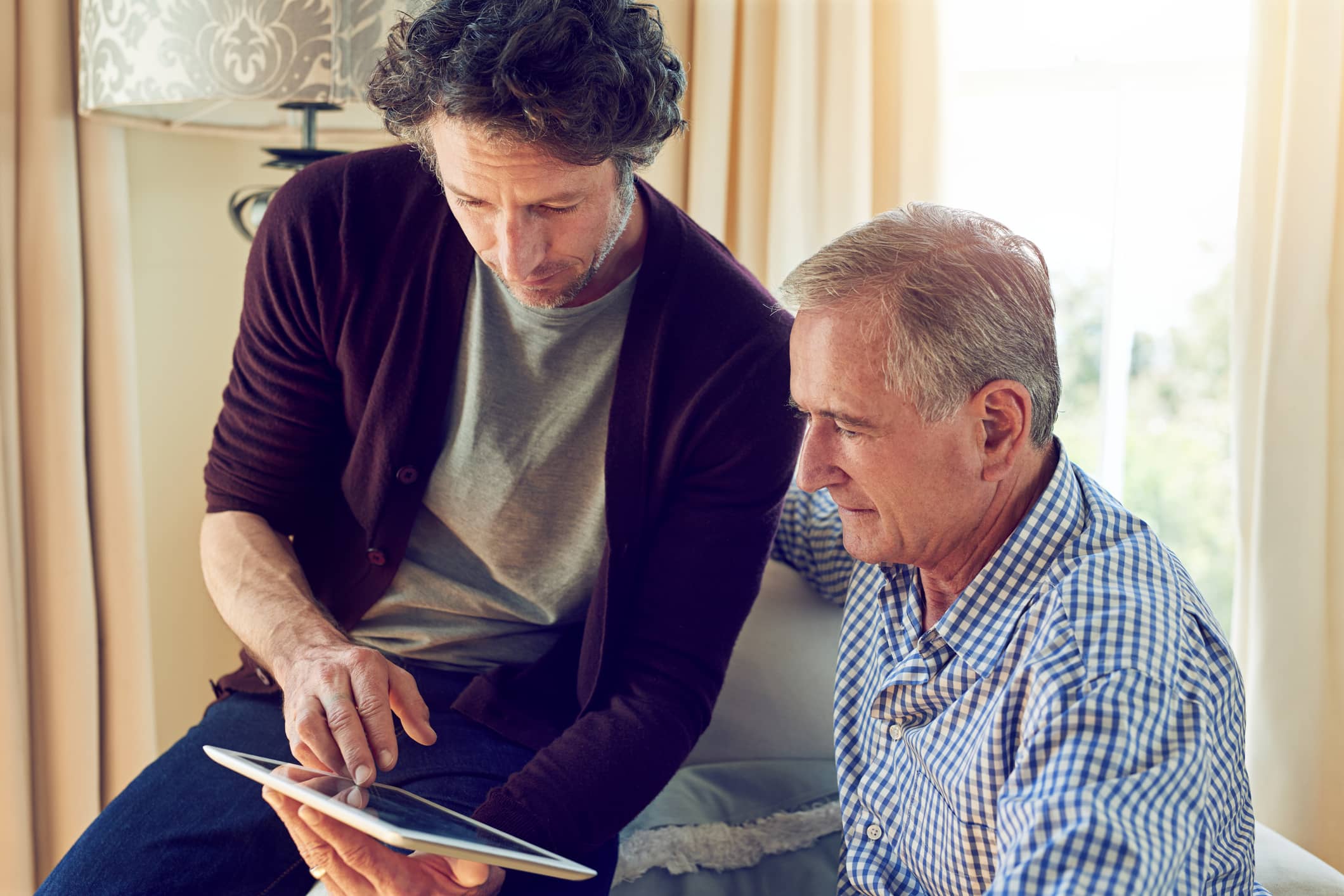 Son helping his father with technology