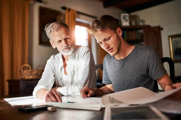 Father and grown son going over finances together.