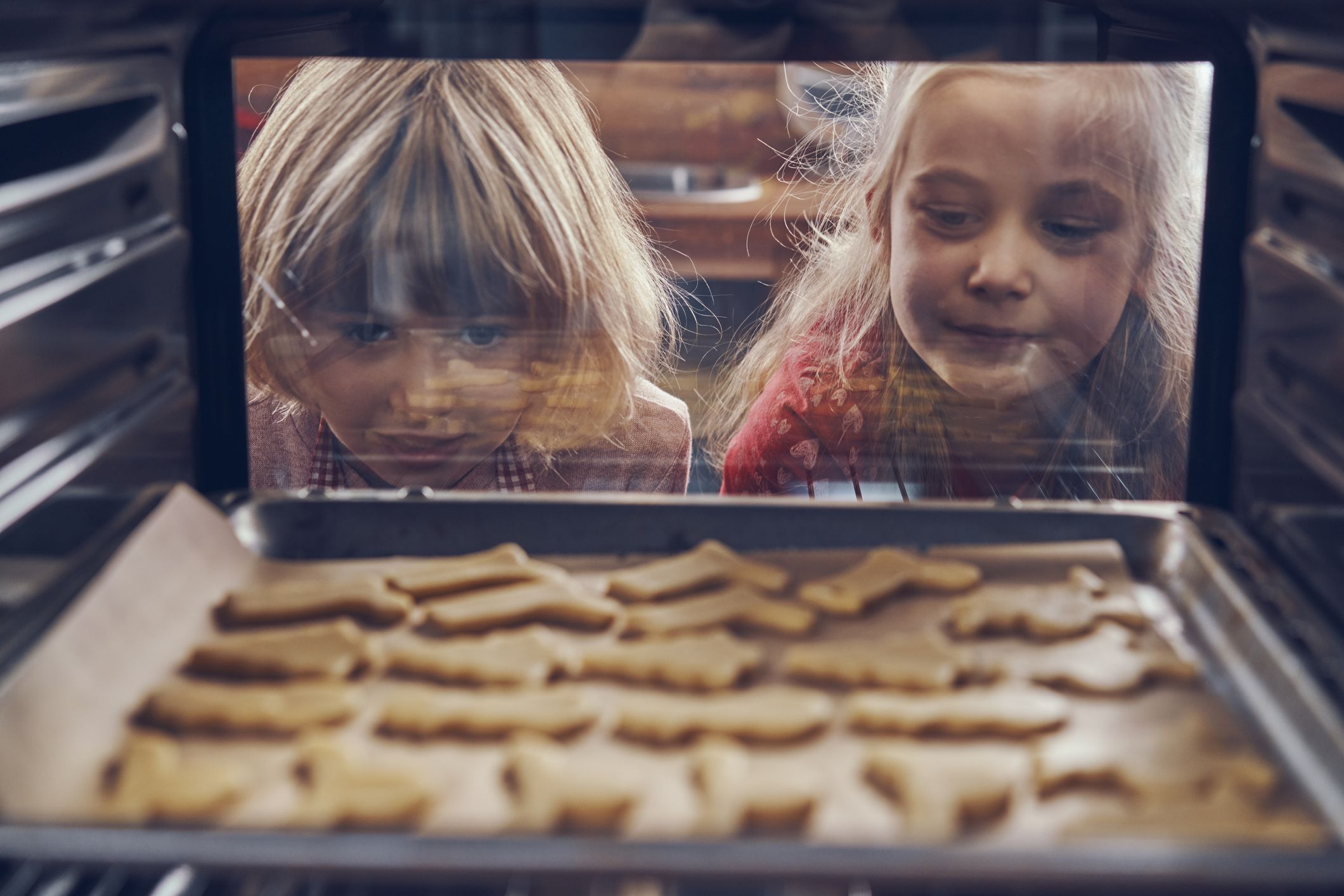 Little girls waiting cookies to bake