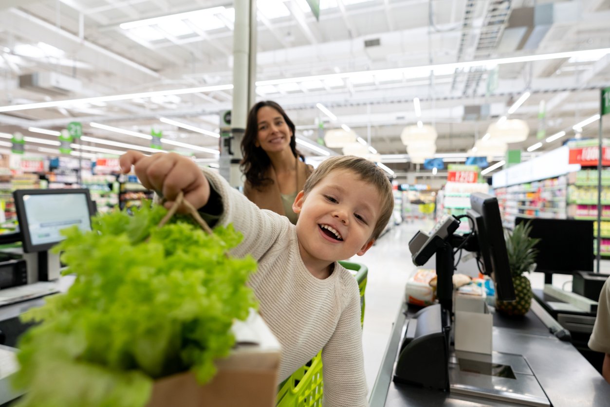 Little boy helping mommy at the grocery store.