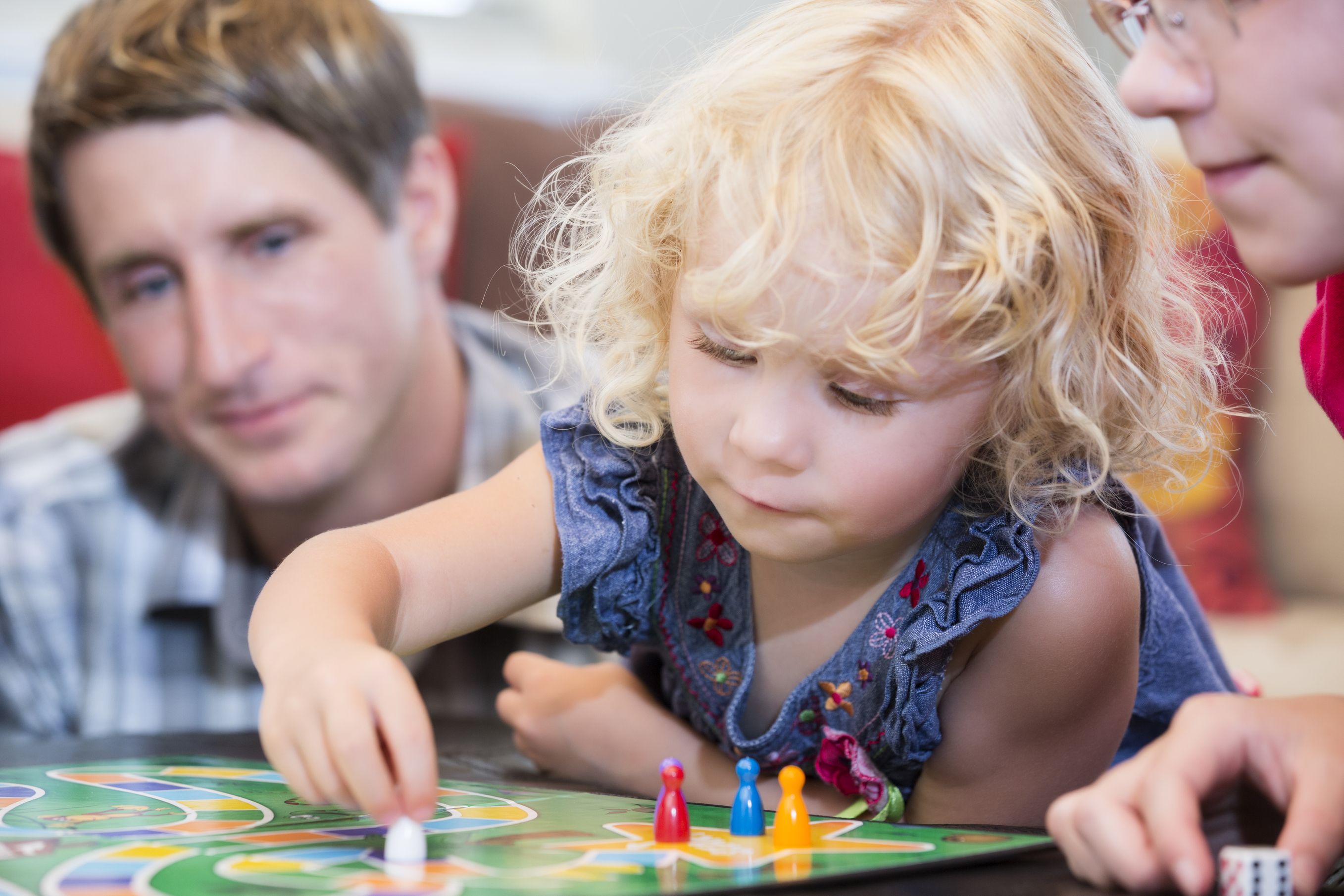 Family playing a game with a preschooler