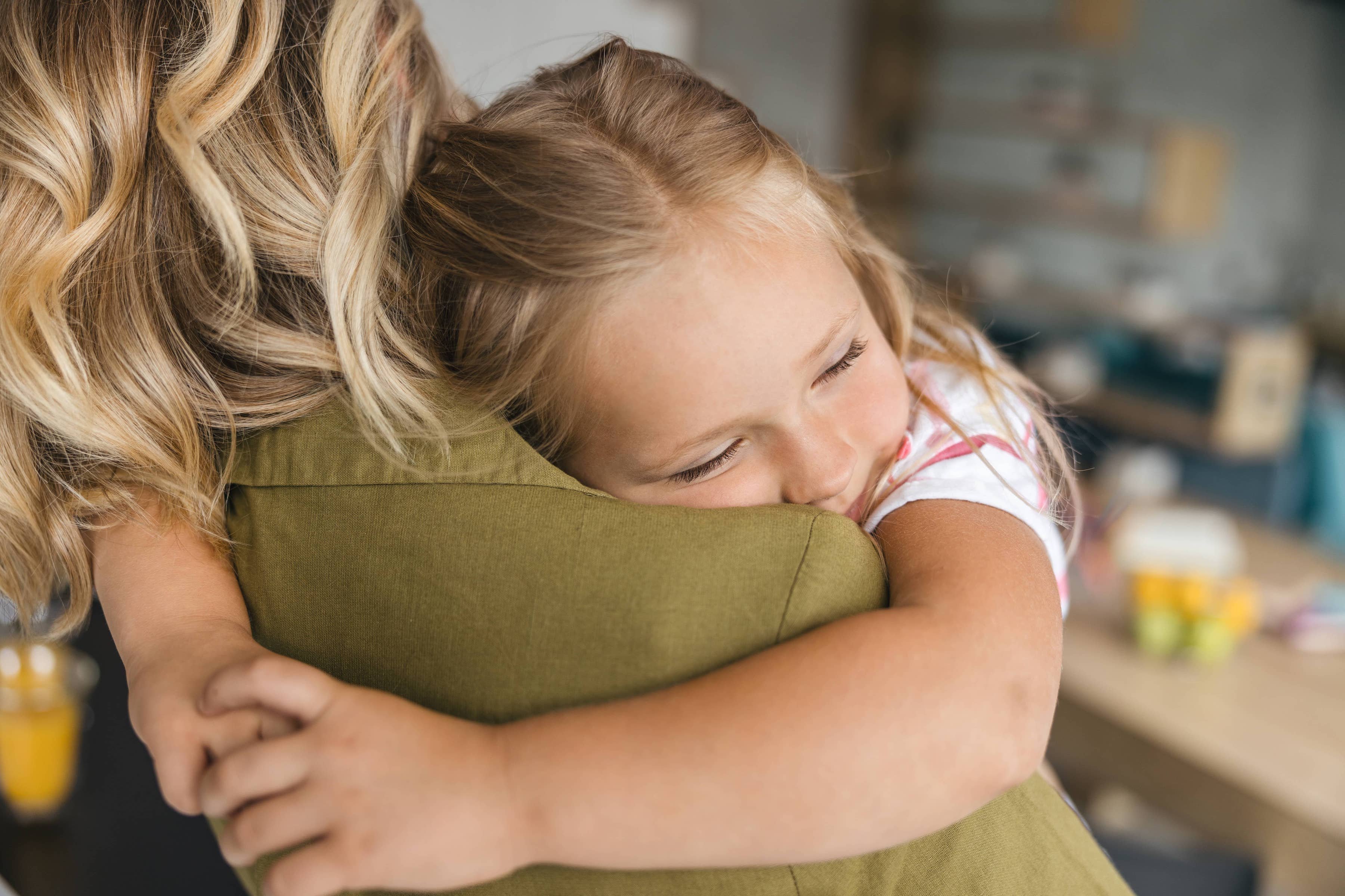 A little girl hugging her mother.