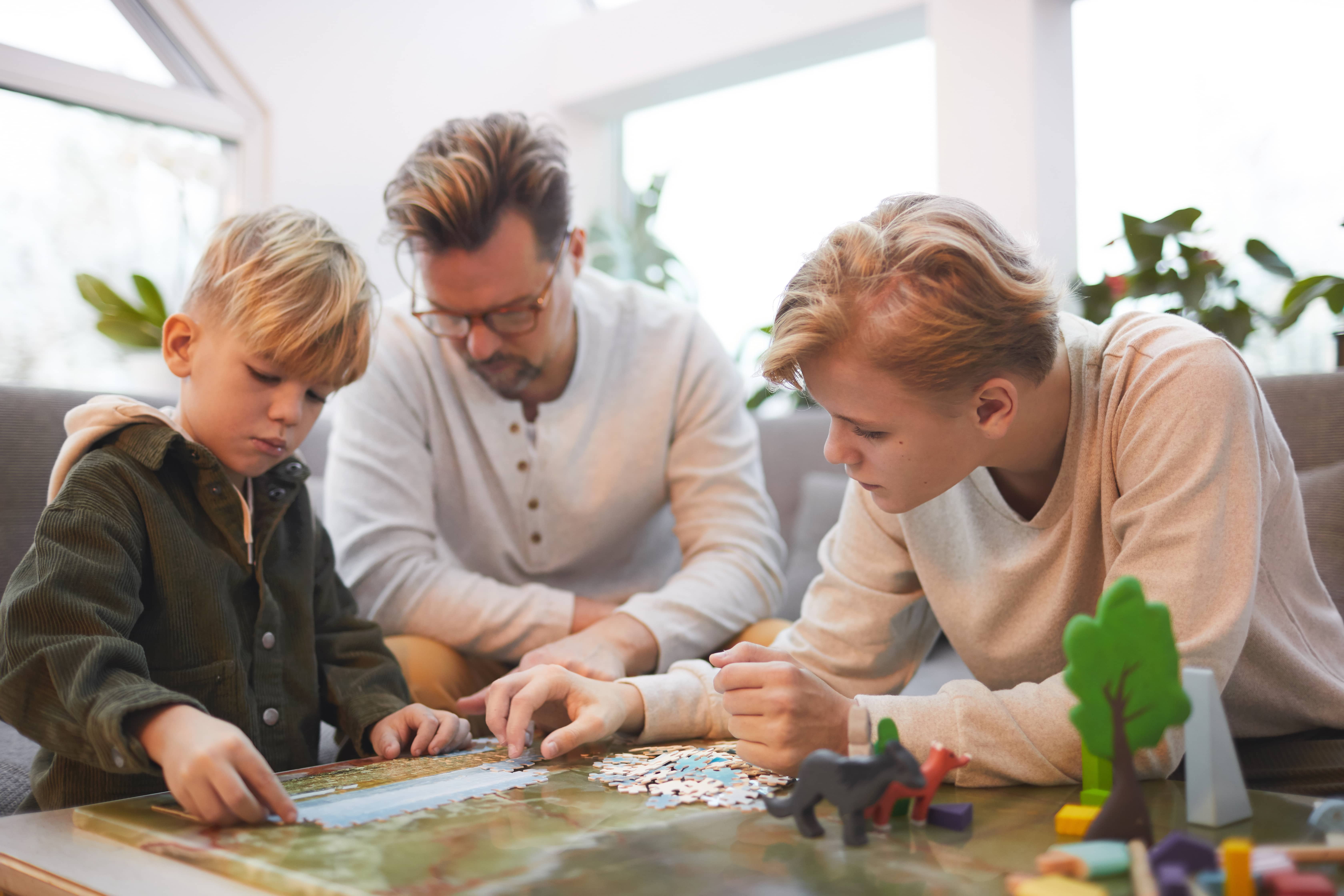 Loving father playing boardgames with his sons.