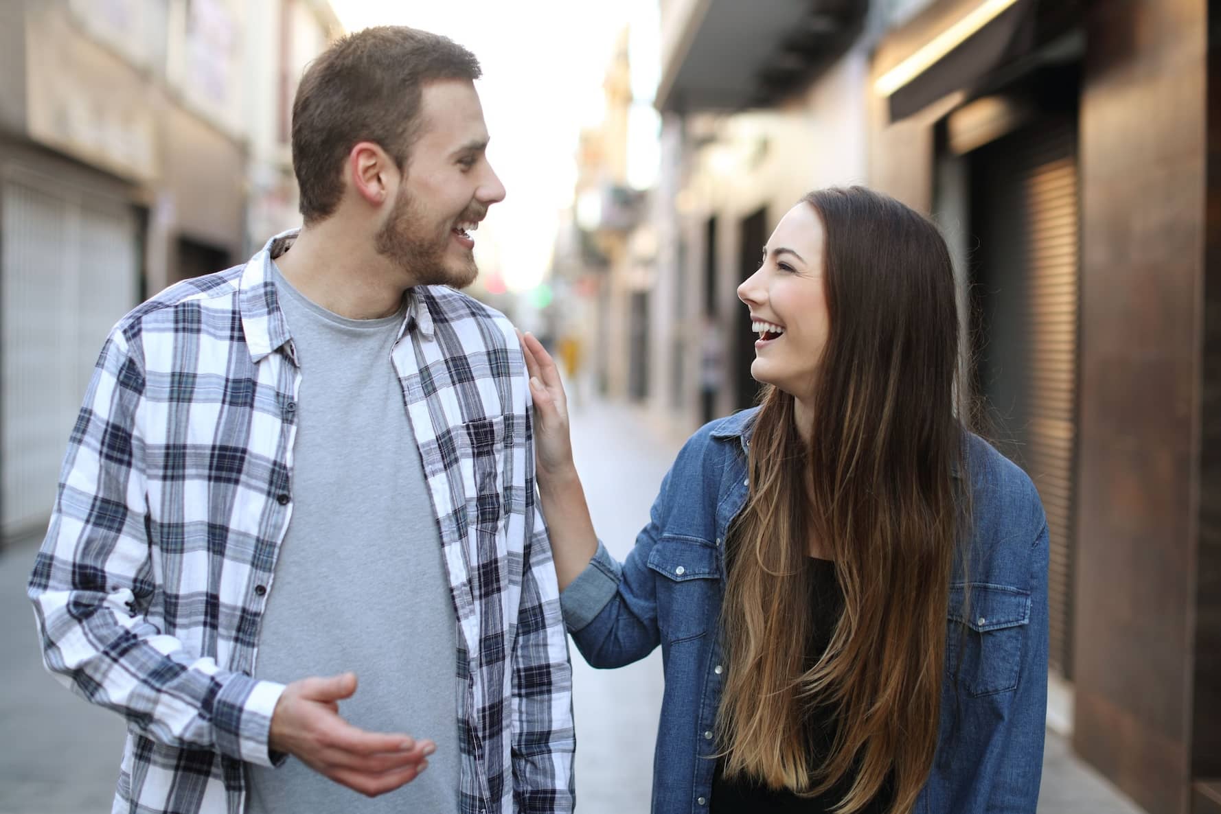 A man and woman smiling while walking.