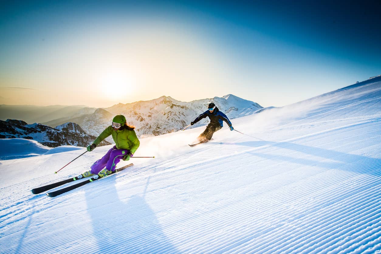 Young couple downhill skiing together