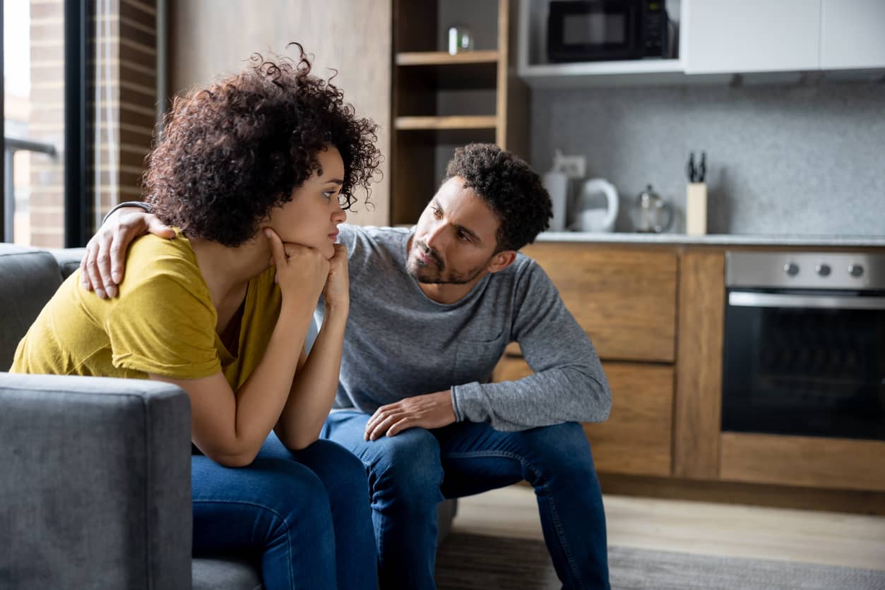 Man comforts his spouse at home.