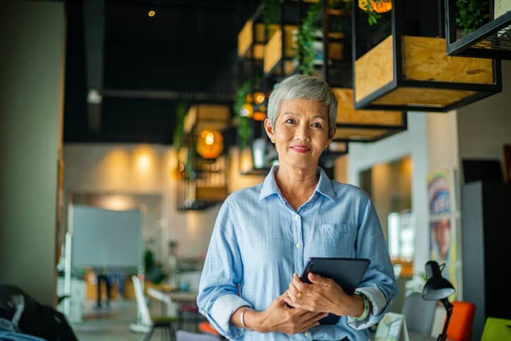 Mature businesswoman holding an iPad and ready for action.