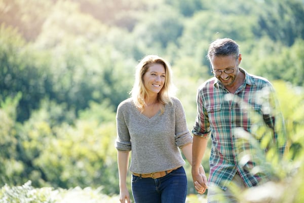 A couple walking hand-in-hand in nature