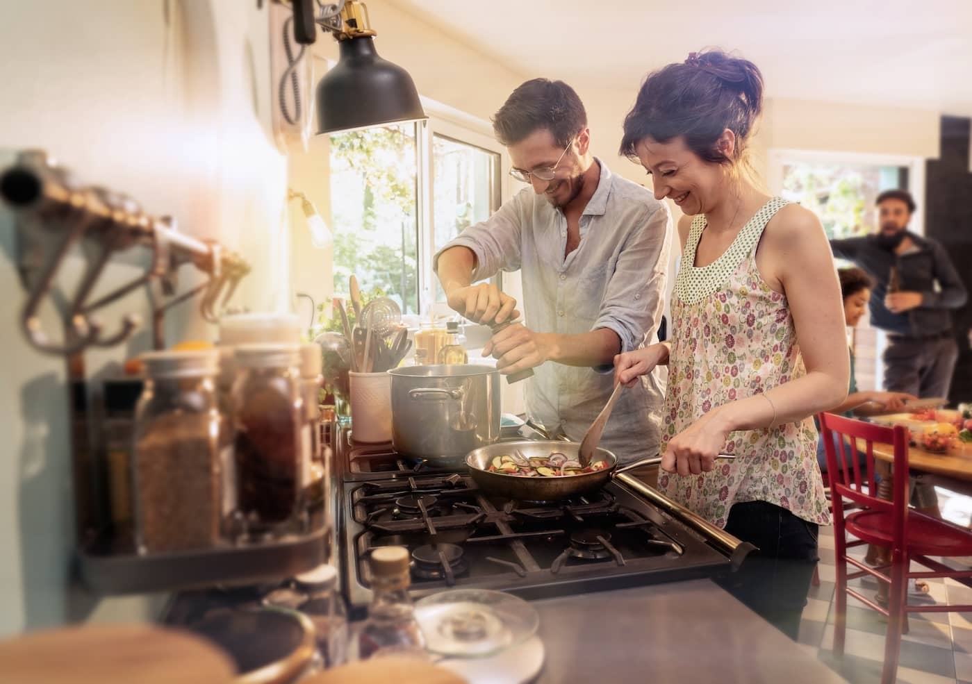 Couple with friends have fun while cooking a meal in kitchen.