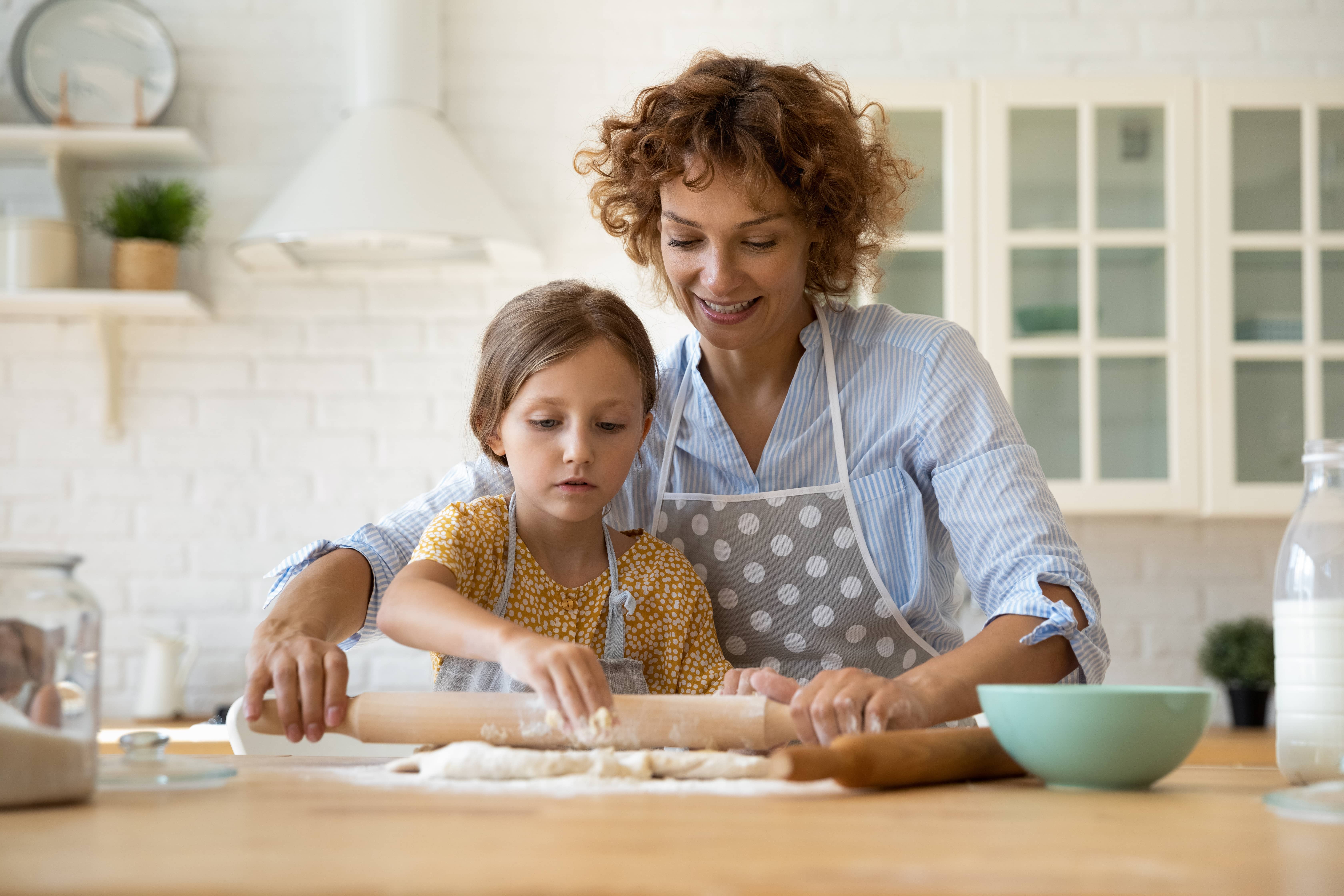 Mother and daughter baking in kitchen.