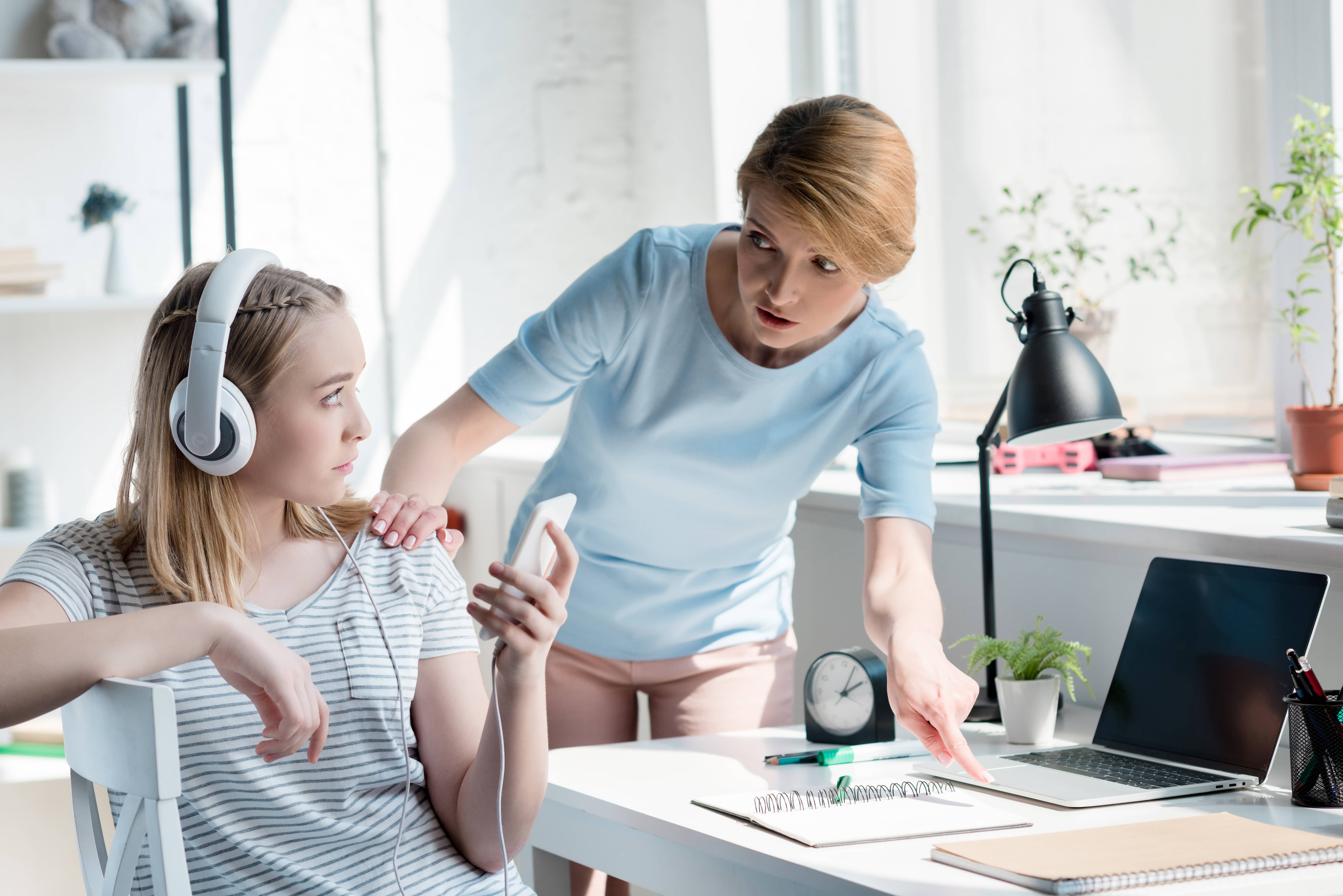 Mother confronting her teenage daughter about cell phone addiction.