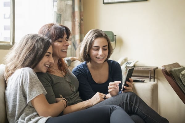 Mother and daughters conversing on the couch