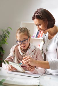 Mother helping her teen with her homework