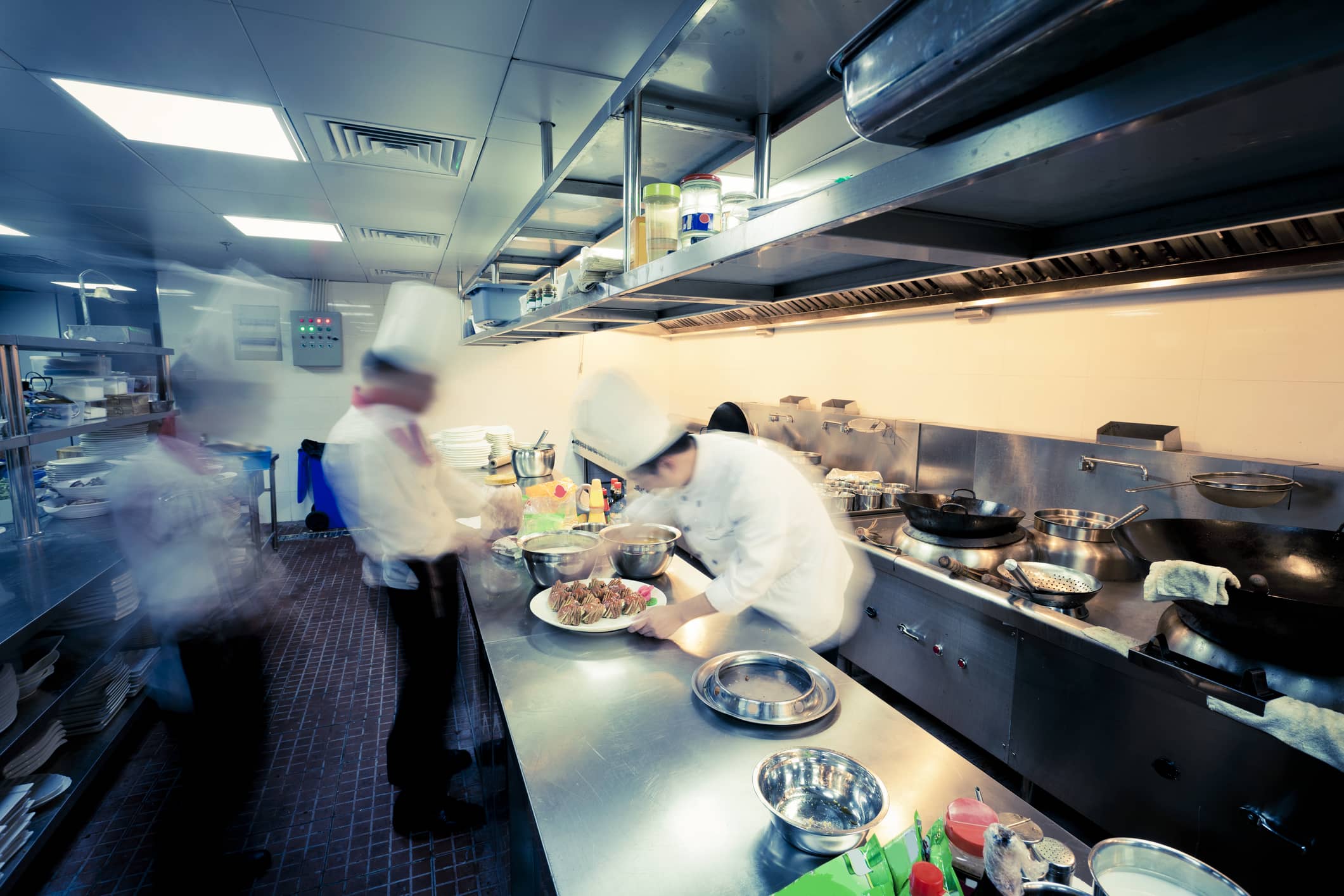 Fast-paced restaurant kitchen with chefs preparing meals.