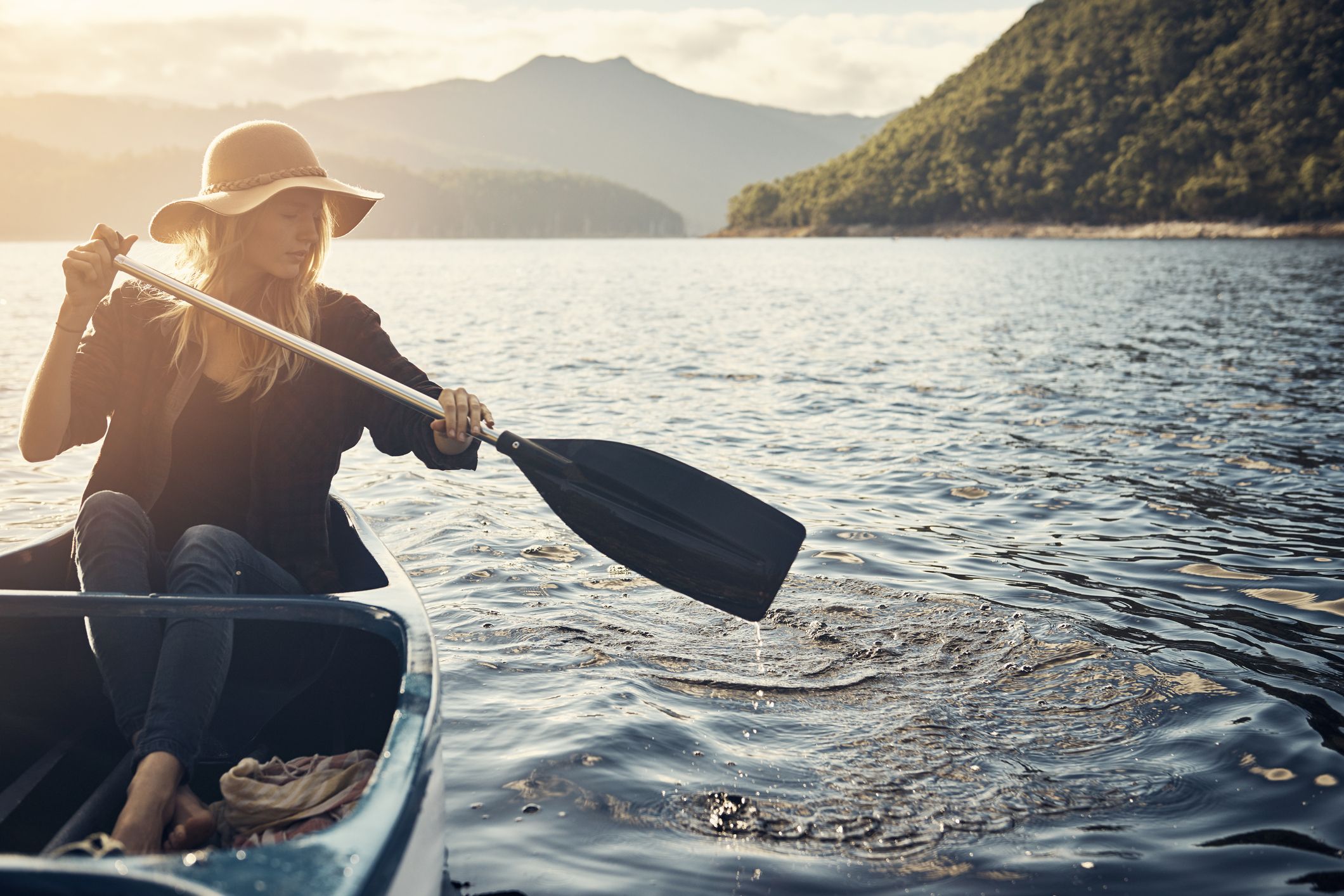 A woman boating on a lake for self-care and solitude