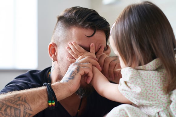 A father playing peek-a-boo with his toddler as a part of cognitive development A father playing peek-a-boo with his toddler as a part of cognitive development