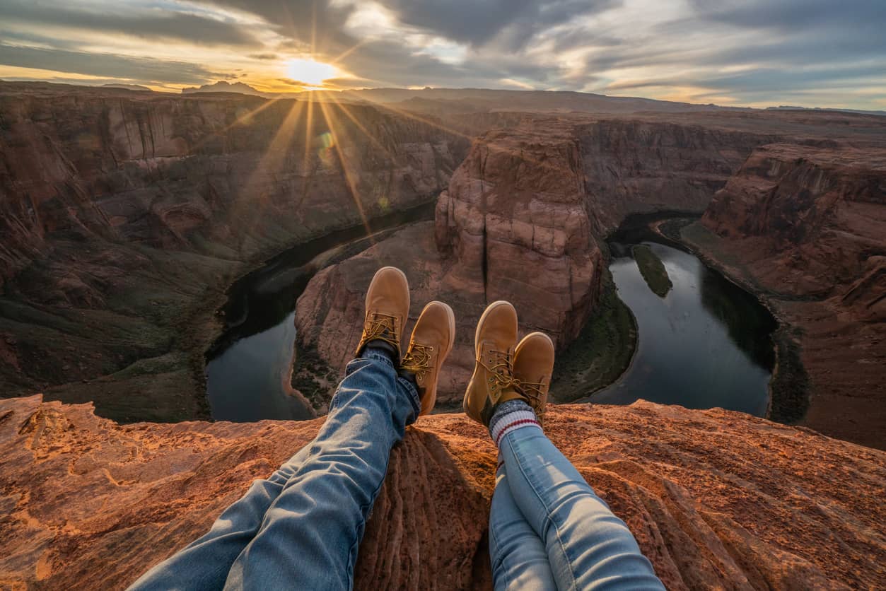 Personal-perspective-of-couple-relaxing-on-top-of-Grand-Canyon;-feet-view;--People-travel-vacations-relaxation-concept-1159370091_Compressed