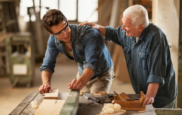 Senior carpenter commending his employee on his work