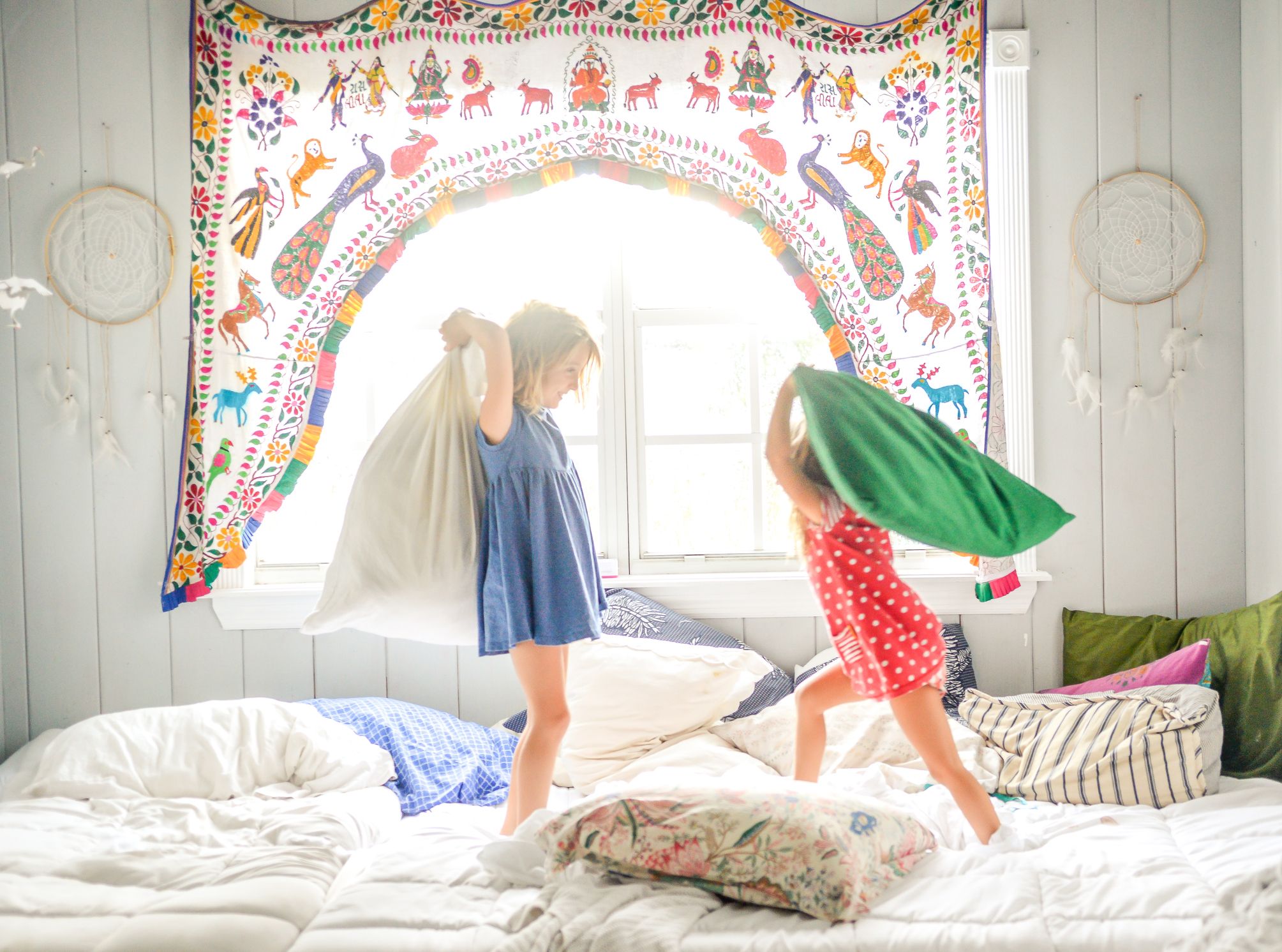 Siblings have a pillow fight in their bedroom
