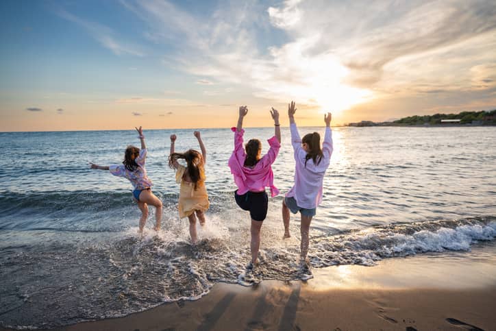 Playful friends having fun on the beach; expressing joy.