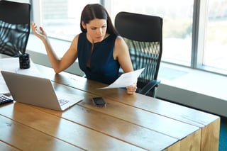 An upset businesswoman reading the latest report