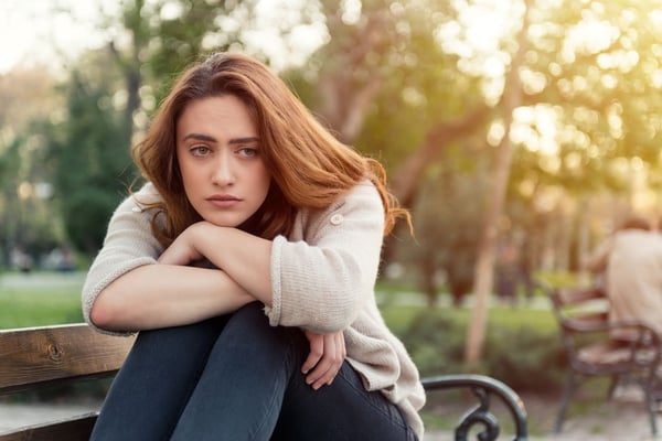 Why am I so emotional? A sad woman with head resting on her knees.