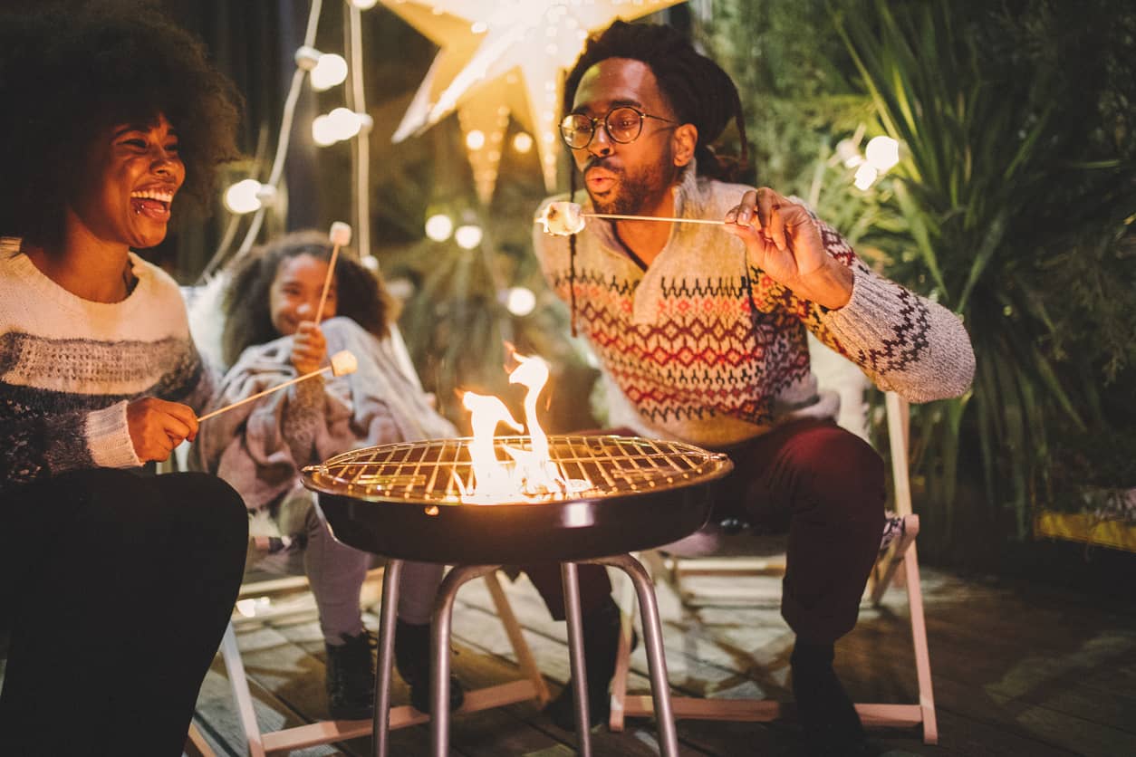 A family creating a memorable experience around a campfire in their backyard.