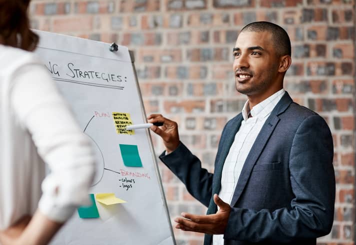 Shot-of-a-young-businessman-presenting-notes-on-a-whiteboard-in-an-office-1319874274_Compressed-1