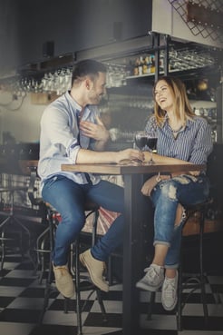 Loving couple laughing over a glass of wine