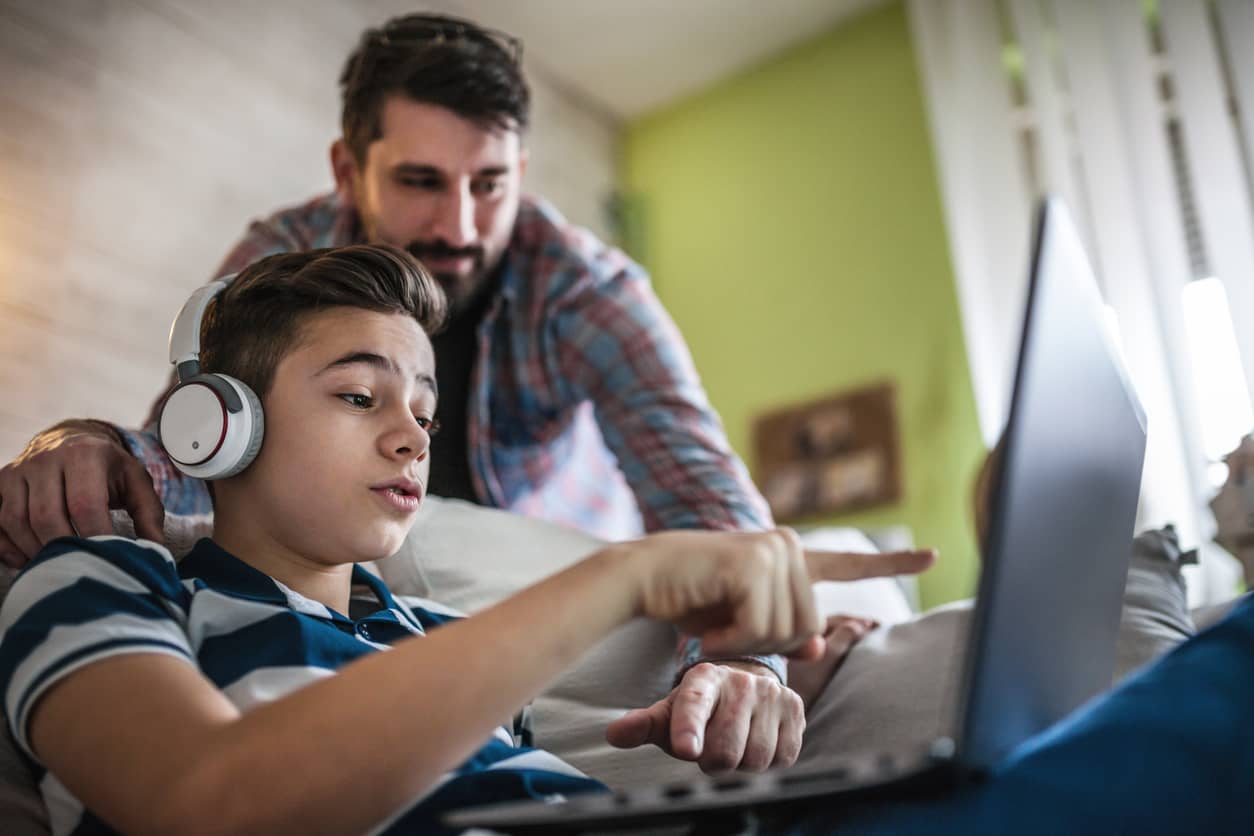 A father and son interacting on a computer