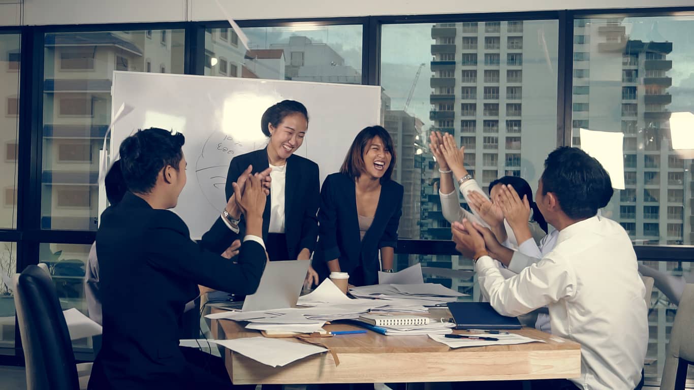 Successful Asian team celebrating their new product launch.