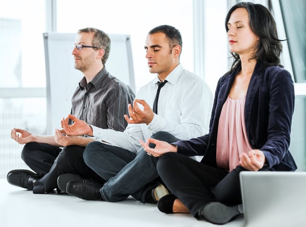 Successful business people meditating in the office