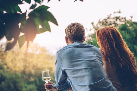 A couple leaning against a fence