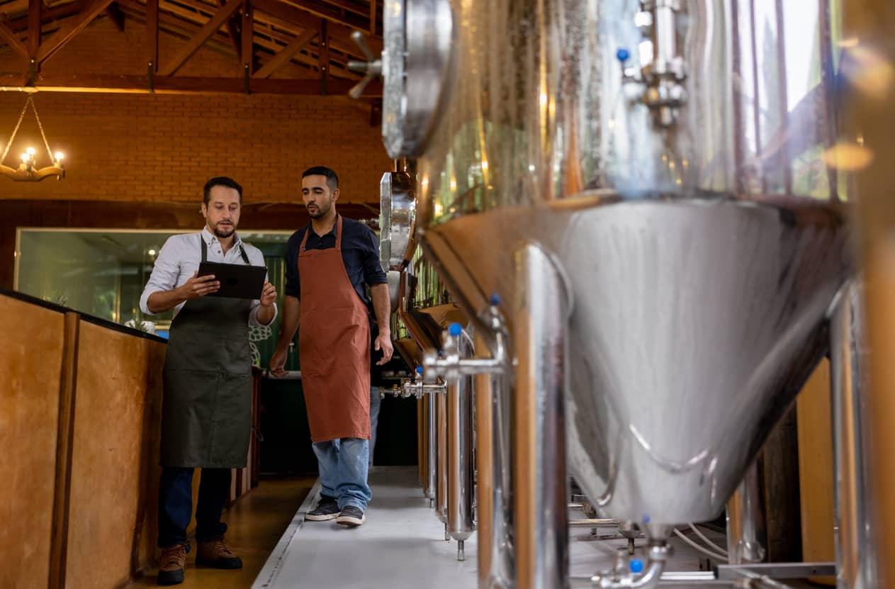 Two men working at a brewery reviewing schedules.