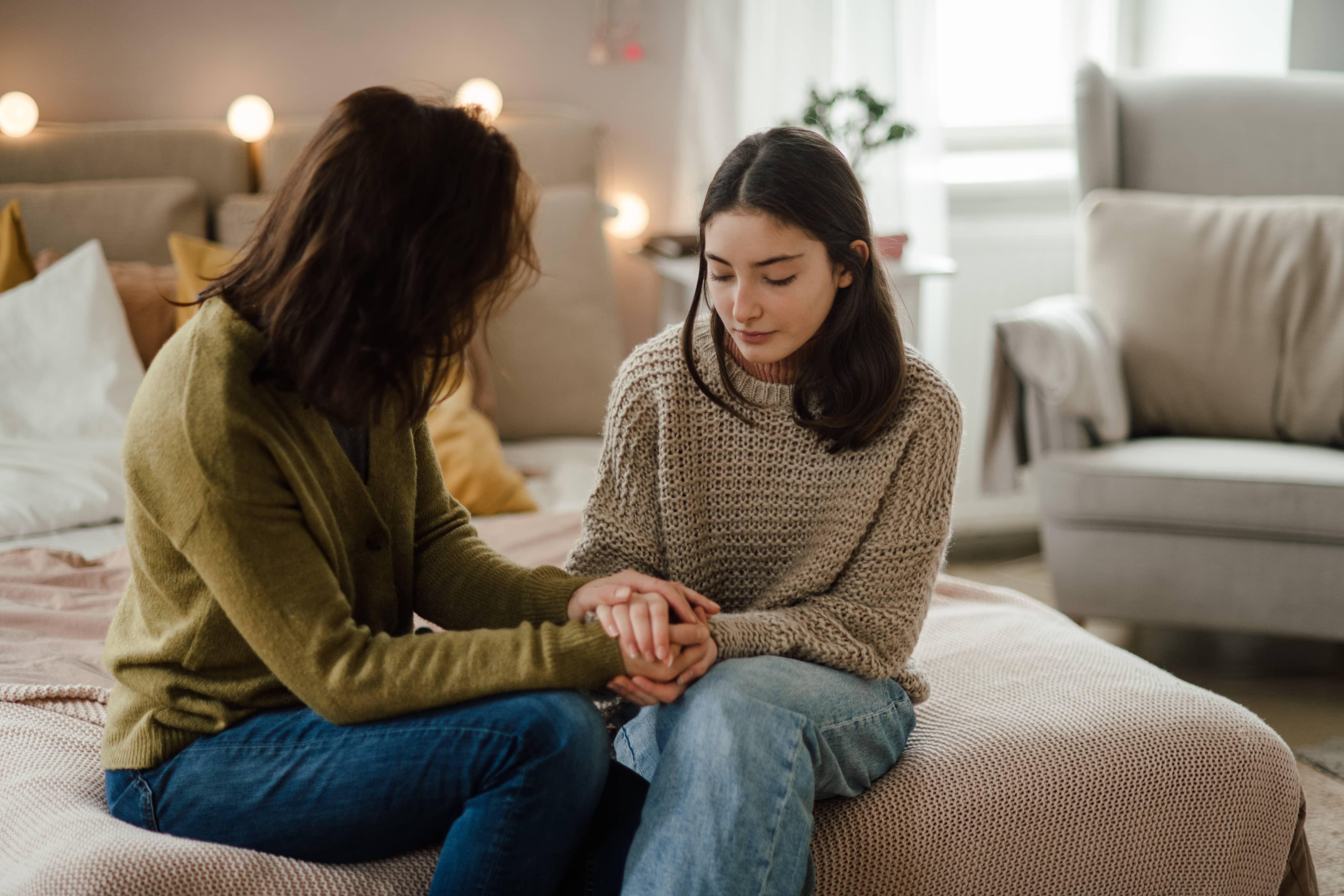 A teenage girl sharing problems with her mom while her mom empathizes.