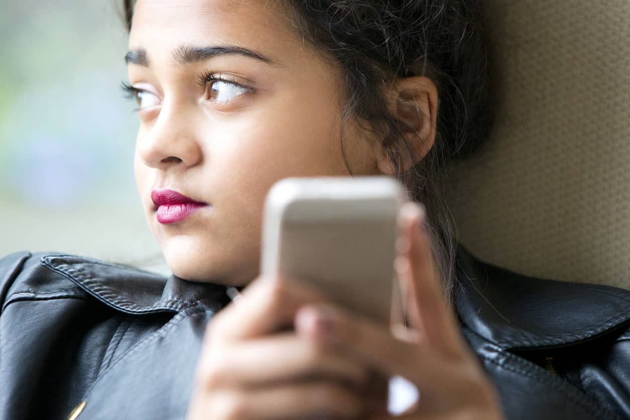 Anxious teen on her mobile phone