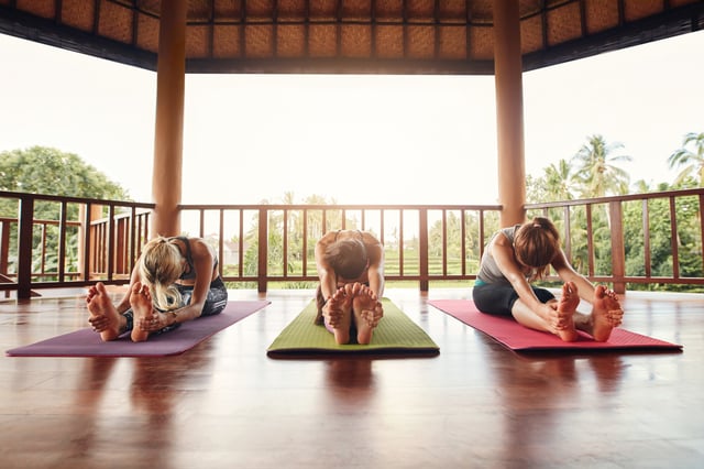 Three women stretching at a yoga class