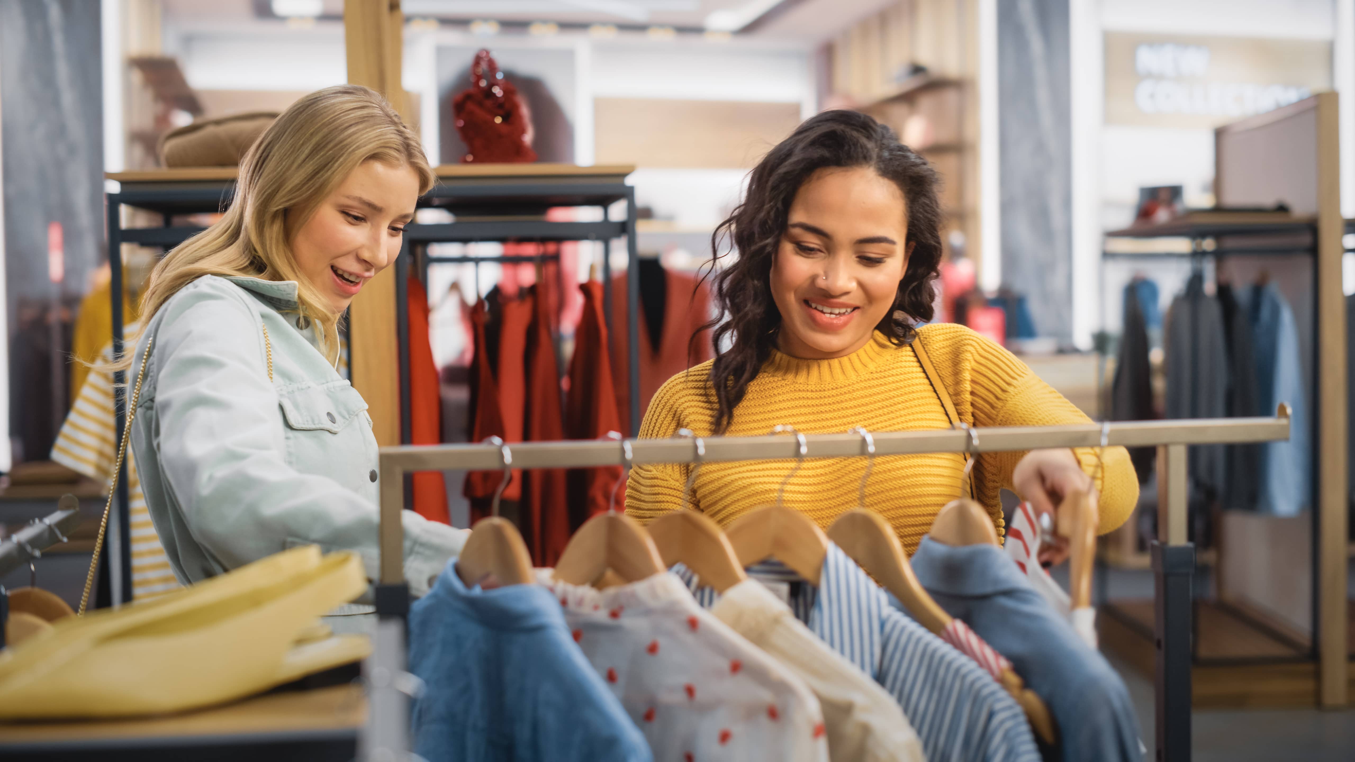 Two teenage girls shopping for clothes.